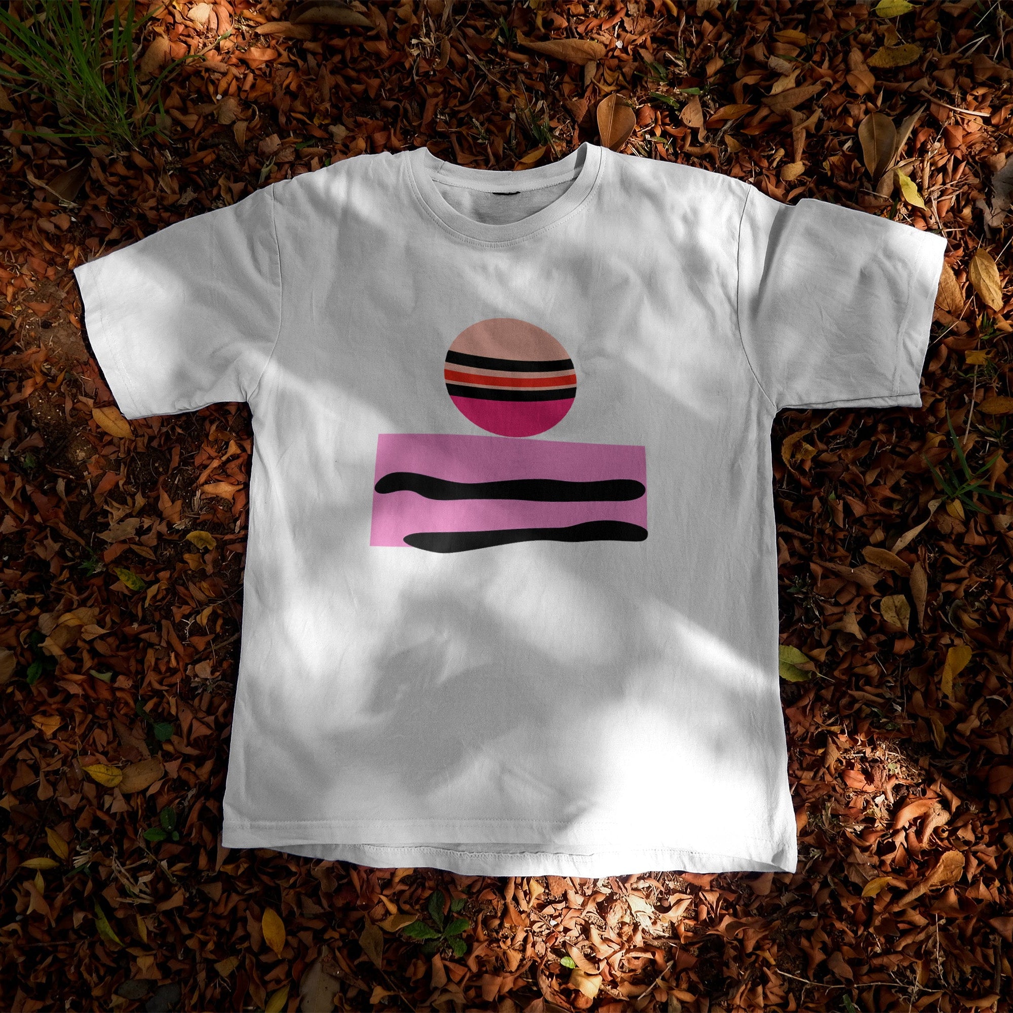 White t-shirt featuring a minimalist abstract graphic of a striped Jupiter planet above a pink geometric block