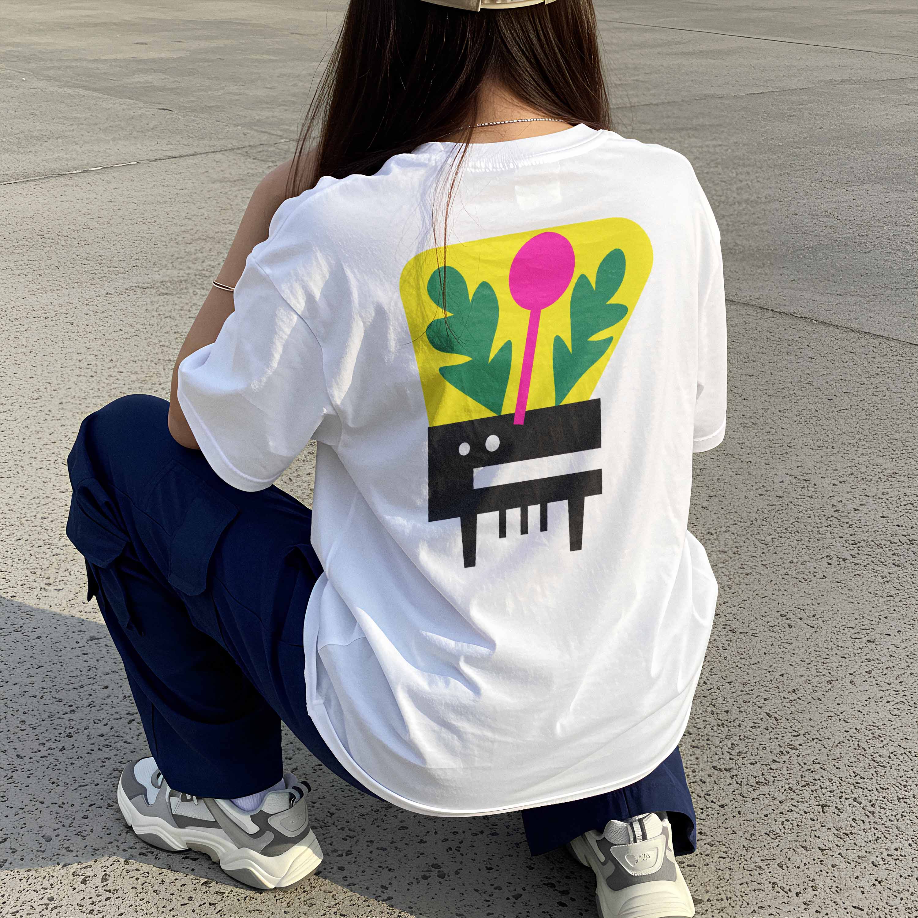 Woman wearing the Plantastic Sound graphic tee, showcasing the piano merged with plant back print and casual streetwear fit