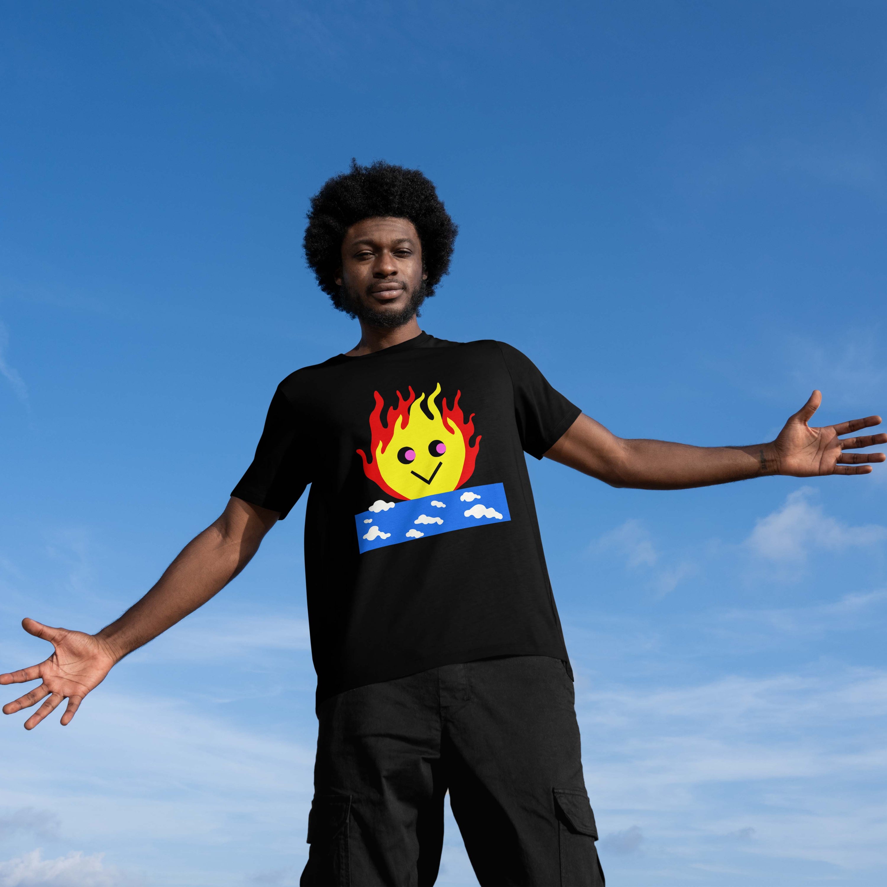 Man wearing a black t-shirt featuring a burning sky graphic with a cute smiling flame character rising from a blue cloud block