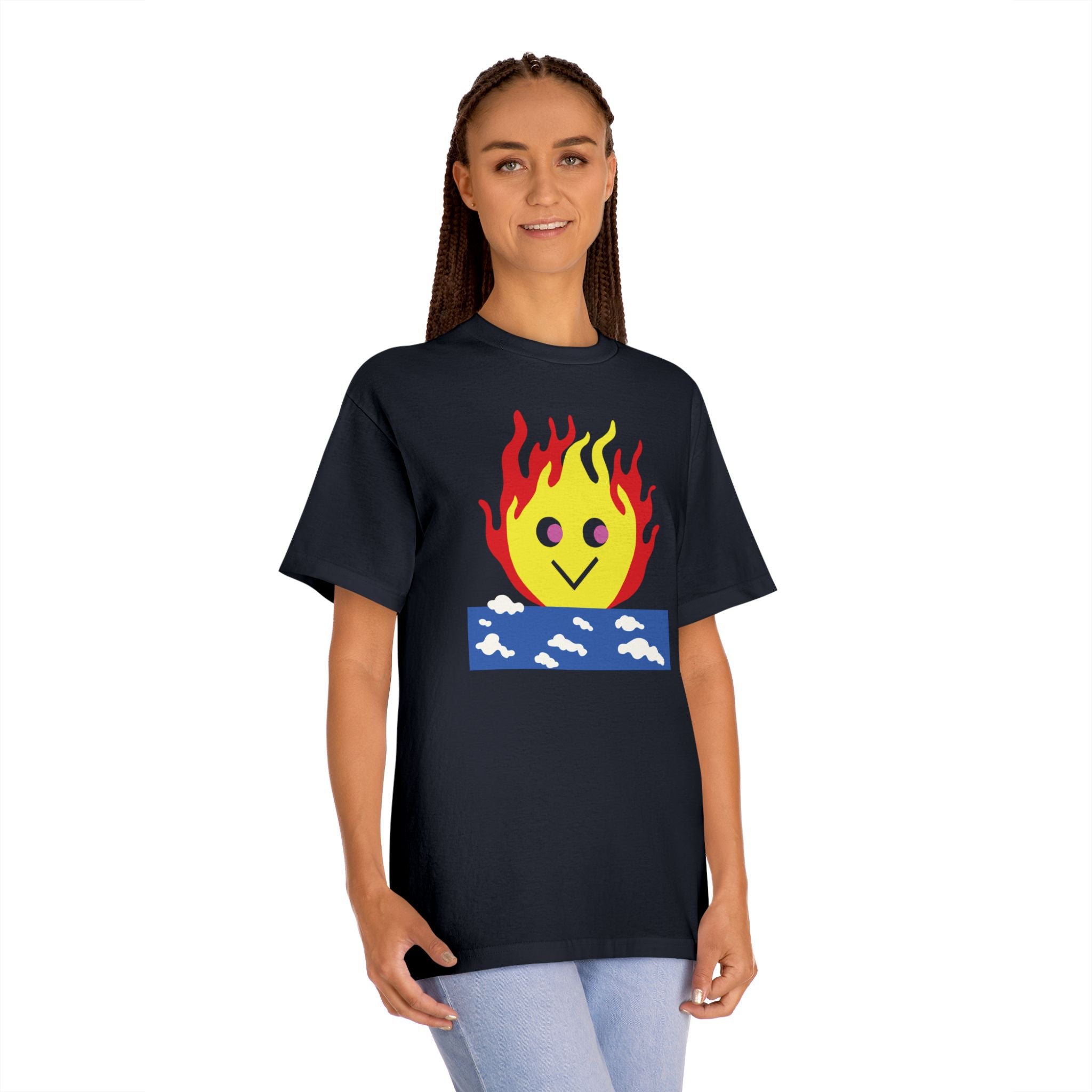 Woman wearing a black t-shirt featuring a burning sky graphic with a cute smiling flame character rising from a blue cloud block
