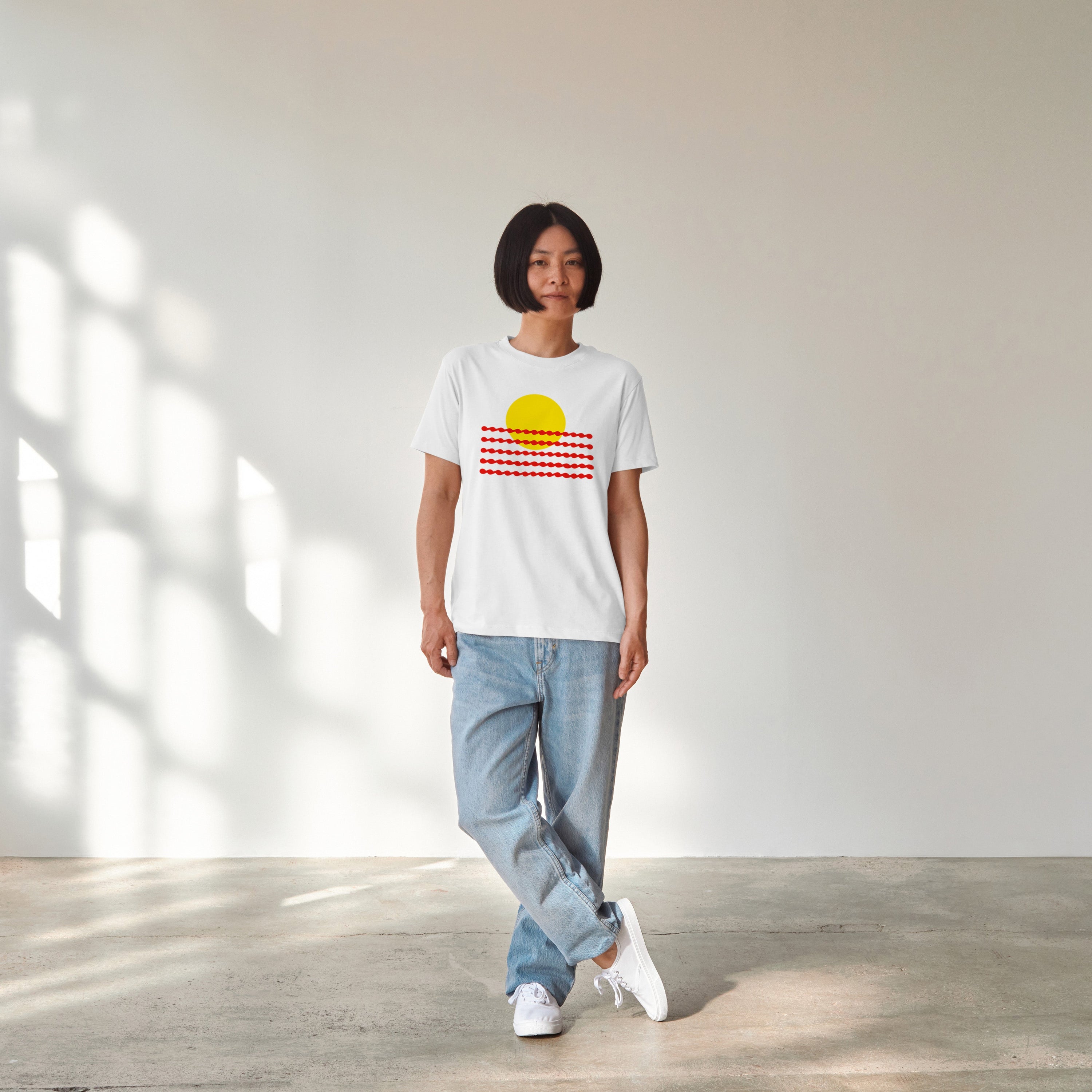 Woman wearing the Sunwaves graphic tee, showcasing the clean geometric sun and wave print on the chest